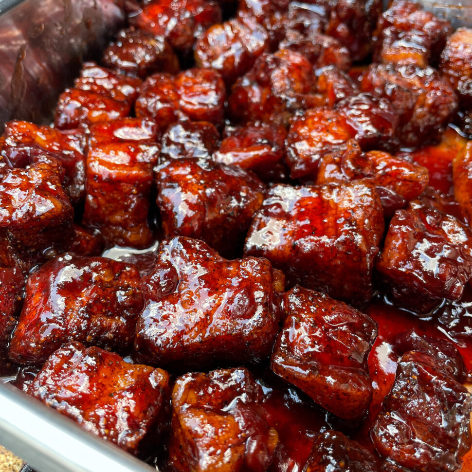 Smoked Pork Belly Burnt ends are tossed in BBQ sauce and returned to the smoker.