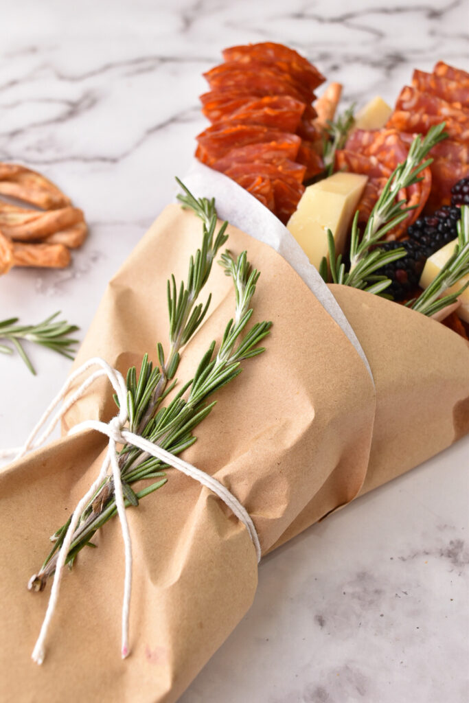 The finishing touches of a meat bouquet - add some twine and a spring of rosemary.